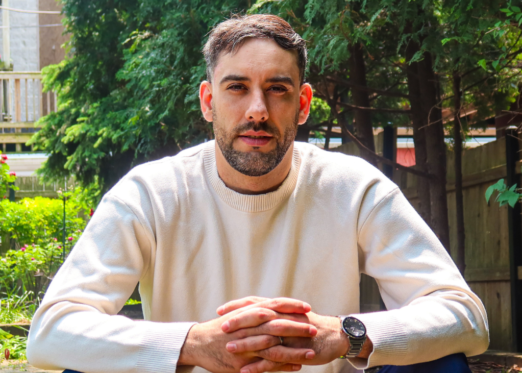 uran kabashi real estate agent with white cashmere sweater sitting in a park